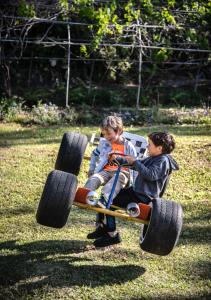 蒙泰韦尔德哥斯达黎加森林花园度假屋的两个孩子骑着一辆带大轮的玩具车