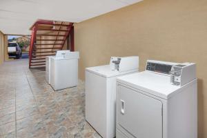 金斯维尔金斯维尔速8汽车旅馆的洗衣房配有白色洗衣机和烘干机