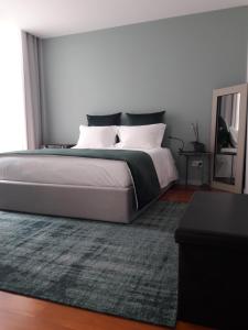 马亚Maia Centro的一间卧室配有一张大床和地毯。
