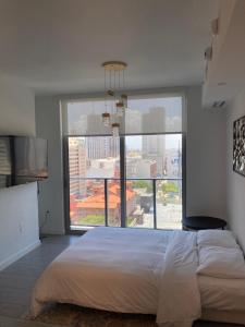 迈阿密Brand NEW modern 1 bedroom unit Downtown的一间卧室设有一张大床和一个大窗户