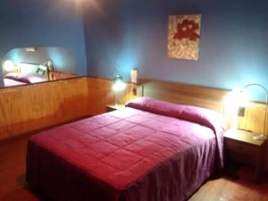 圣费尔南多Hostal Valle Central San Fernando, Chile的一间卧室配有一张带红色毯子的床