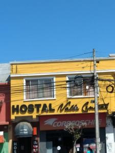 圣费尔南多Hostal Valle Central San Fernando, Chile的黄色建筑,上面有酒店标志