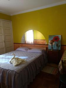 圣费尔南多Hostal Valle Central San Fernando, Chile的一间卧室设有一张黄色墙壁的大床