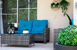 基西米Private house Kissimmee/Orlando的天井上的带蓝色枕头的藤椅