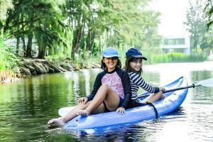 后川PLAYA Villa in Sanctuary Resort - 100m from Private Beach - New 2023的两个女孩坐在水上的皮艇上