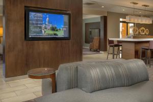 Orange纽黑文奥兰治万怡酒店的客厅配有沙发和墙上的电视