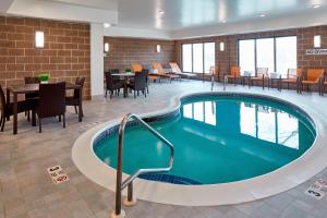 奥尔巴尼Courtyard by Marriott Albany Thruway的游泳池位于酒店带桌椅的客房内