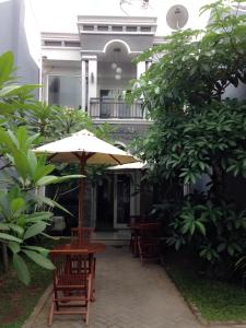 日惹萨法度假屋的大楼前的桌椅和遮阳伞