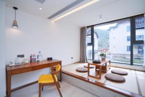 青岛青岛九水和园艺术设计酒店的一个带书桌和窗户的家庭办公室