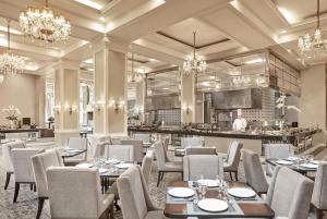 马尼拉黎刹公园酒店 的一间带桌椅的餐厅和一间厨房内的厨师