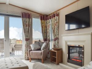 Stonham AspallLodge 69的客厅设有壁炉和电视。