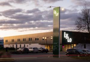 基督城LyLo Christchurch的停车场内停放汽车的大型建筑