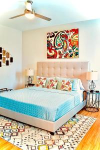 查塔努加Cityscape 2 -Sleep 7的卧室配有一张床,墙上挂有绘画作品