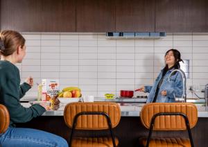 基督城LyLo Christchurch的两名妇女坐在厨房的柜台上