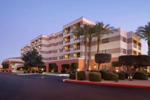 斯科茨Courtyard by Marriott Scottsdale Old Town的一座棕榈树和灌木丛的建筑