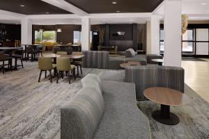 休斯顿Courtyard by Marriott Houston Rice University的大堂配有沙发和桌椅