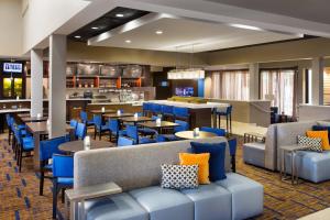 凤凰城Courtyard by Marriott Phoenix North的一间设有蓝色桌椅的餐厅和一间酒吧