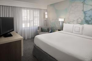 休斯顿休斯顿威斯特契斯万怡酒店的酒店客房设有一张大床和一台电视。