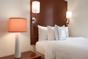 波特兰Residence Inn Portland Downtown Waterfront的酒店客房配有一张床和一张带台灯的桌子