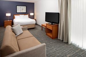 列克星敦列克星敦北原住酒店的酒店客房配有床、沙发和电视。
