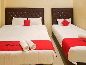 沙璜RedDoorz Syariah At Harley Hotel Sabang的一间卧室配有两张红色和白色床单