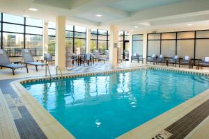 罗宾逊镇匹兹堡万怡塞特勒斯里奇鲁滨逊酒店的一座配有桌椅的酒店游泳池