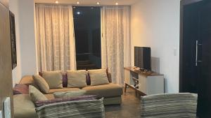 蓬塔布兰卡Punta Centinela Apartment的带沙发和电视的客厅