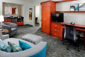 罗宾逊镇匹兹堡万怡塞特勒斯里奇鲁滨逊酒店的客厅配有沙发和书桌及电视