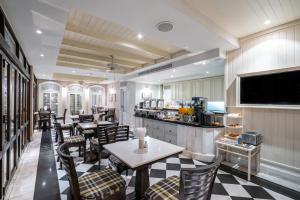 曼谷拉普提萨利尔素坤逸8的一间带桌椅和电视的餐厅