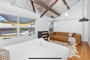 North Fremantle5 North Freo 2br Supercool Pad & Parking的白色卧室配有床和沙发