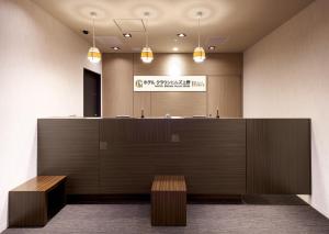 东京Hotel Crown Hills Ueno Premier的一个带前台和长凳的办公大厅