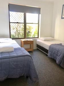 玛志洛卡鲁阿度假公寓酒店的客房设有两张床、一个窗口和一张桌子