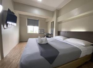 马尼拉塞勒姆DG经济型酒店的一间卧室配有一张大床和电视