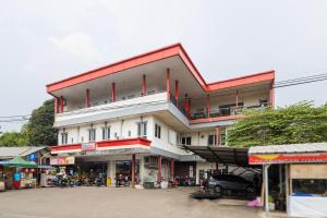 当格浪Alfa Guesthouse Serpong Mitra RedDoorz的一座白色的大建筑,有红色的屋顶