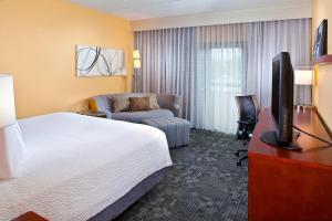 迈阿密迈阿密机场西/多拉尔万怡酒店的酒店客房配有1张床、1台电视和1张沙发。