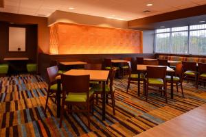 普利茅斯Fairfield Inn & Suites by Marriott Plymouth White Mountains的一间在房间内配有桌椅的餐厅