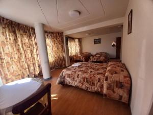 普诺HOSTAL SUMITA HOUSE_INN的酒店客房,设有两张床和窗帘