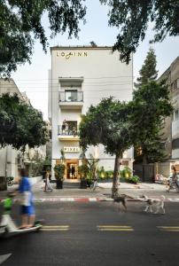 特拉维夫Pixel Dizengoff Square - Smart Hotel by Loginn Tel Aviv的一座建筑,前面的人跑