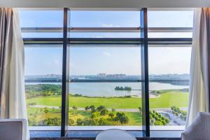 徐州徐州伊敦康得思酒店的客房设有大窗户,享有湖景