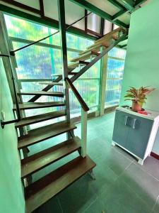 AfareaituMOOZ LODGE, the local discovery的木楼梯,在一座种植了盆栽植物的建筑中