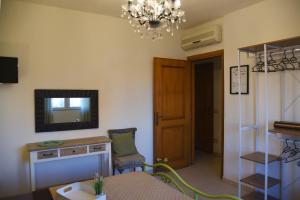 奥尔比亚SOLEMARE Rooms - CAMERA SUGHERO的客厅配有桌子和墙上的电视