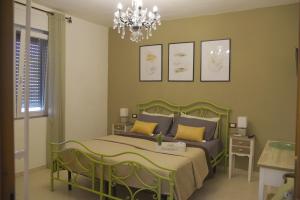 奥尔比亚SOLEMARE Rooms - CAMERA SUGHERO的一间卧室配有一张绿色的床和吊灯。