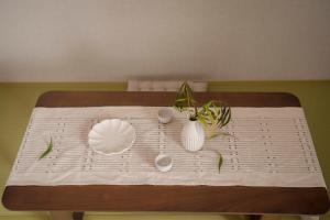 大阪川House道頓堀的一张桌子,上面有白色的板子和花瓶