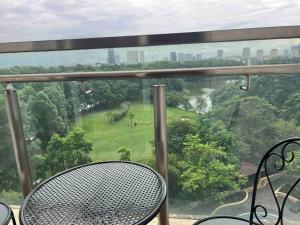 河内Luxury Golf view Apartment Ciputra L2的阳台配有桌椅,享有公园的景致。