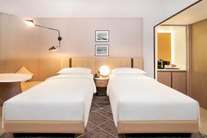 阿布扎比喜来登阿布扎比度假酒店的配有镜子的酒店客房内的两张床