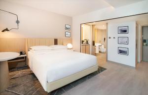 阿布扎比喜来登阿布扎比度假酒店的一间卧室配有一张床、一张书桌和一面镜子