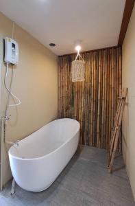 哈林海滩U're Holitel的浴室设有白色浴缸,浴室设有木墙