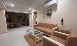 海得拉巴FabHotel Prime AM Suites Near Yashoda Hospital的带沙发和玻璃桌的客厅