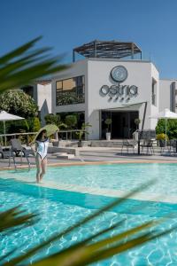 卡尼奥提奥斯特海滨酒店的游泳池里一个有冲浪板的女人