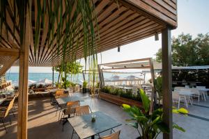 卡尼奥提奥斯特海滨酒店的一个带桌椅的户外庭院和大海